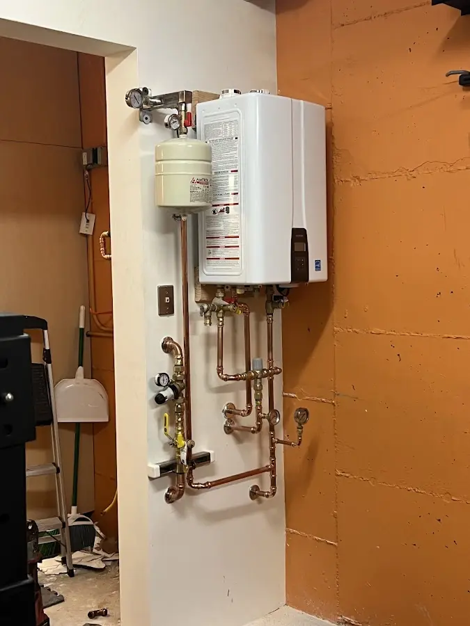 Plumbing technician inspecting water heater connections in Huntingdon